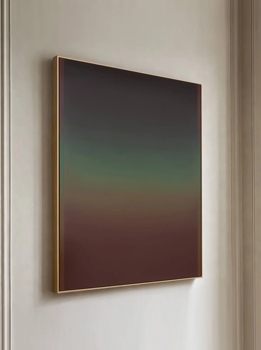 A framed painting seen at an angle against a warm wall, muted green above giving way to a deep russet lower half.